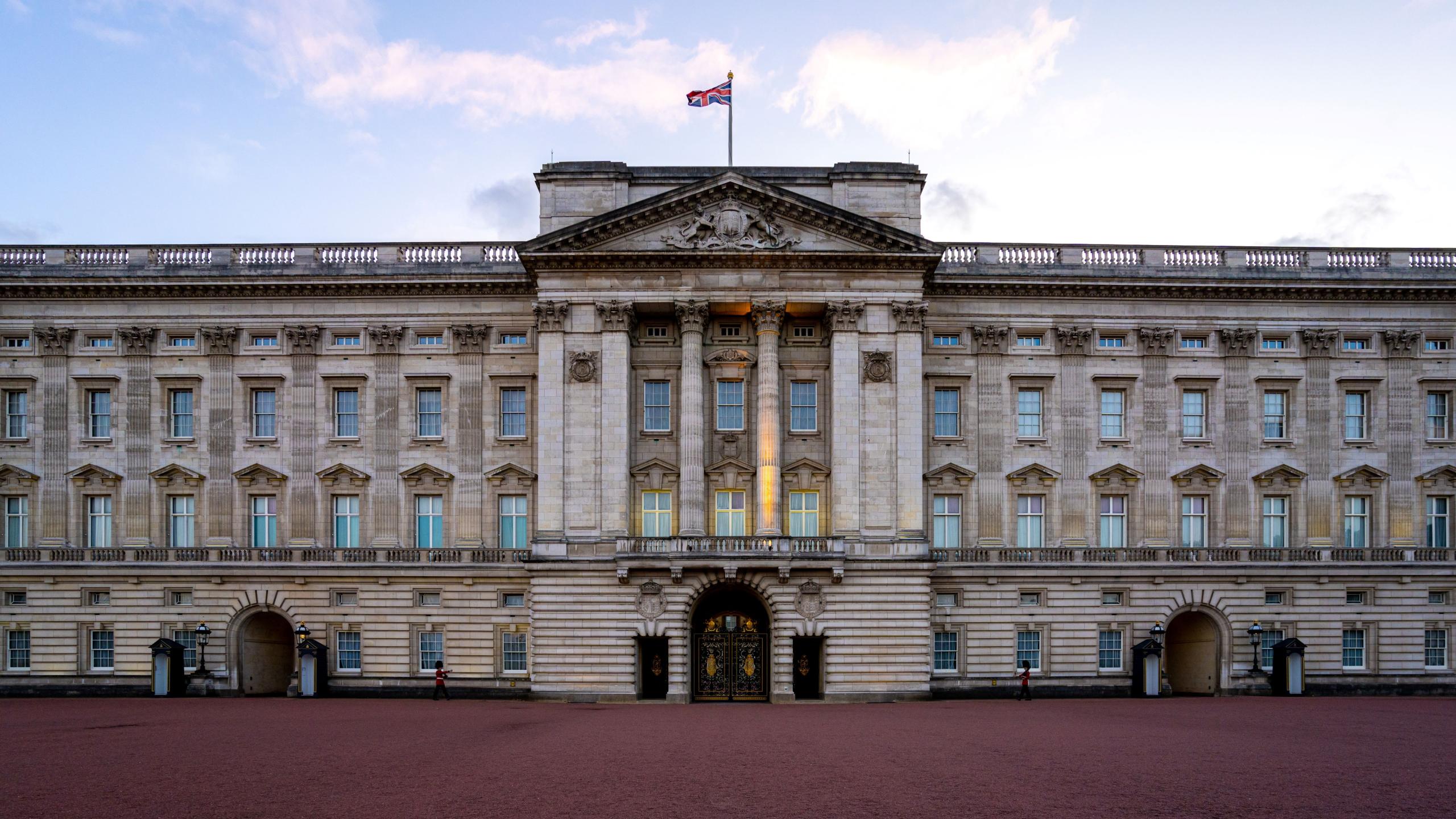 The front of Buckingham Palace with a blue sky in the background.