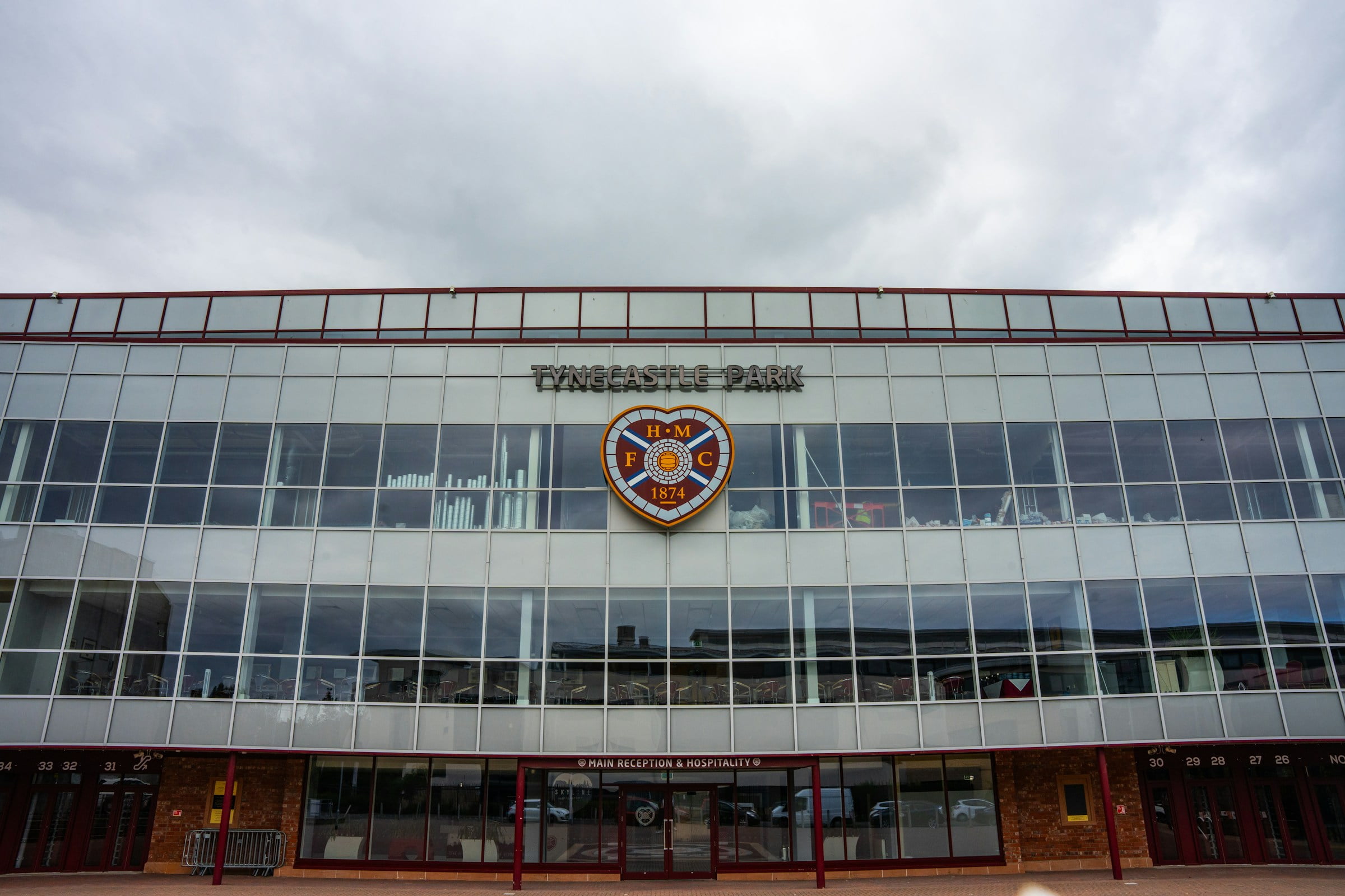 Front view of Tynecastle Park stadium, with cloudy skies behind it.